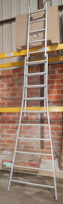 a ladder leaning against a brick wall in a warehouse