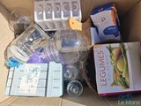 a cardboard box filled with items that include a baby bottle, a bottle of water, and other items