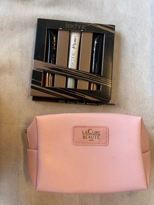 un sac à main rose et deux mascaras posés sur une table