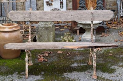 un banc en bois posé devant un bâtiment en pierre