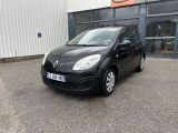 une photo d'une petite voiture noire garée devant un immeuble