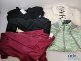several jackets and pants are laid out on a white surface