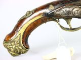 an old gun that is on display on a white surface
