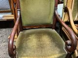 an image of a green chair with a wooden frame and green upholstered seat
