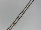 Gros plan sur un bracelet en or orné d'une croix