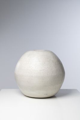 un vase blanc posé sur une table blanche