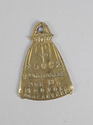 an old brass bell with a bell on top of it on a white surface
