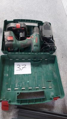 une boîte verte contenant des outils, posée sur le sol