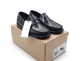 Mocassins noirs pour homme présentés dans une boîte sur fond blanc
