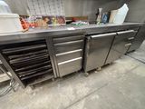 a large stainless steel counter with a bunch of food in it