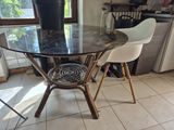 une table en verre sur laquelle se trouvent deux chaises et un vase