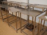 a row of tables in a room with a dog bowl on the floor
