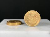 un gros plan d'une pièce d'or posée sur une boîte blanche