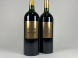 two bottles of wine sitting on top of a white table