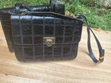 an image of a black purse sitting on a wooden table