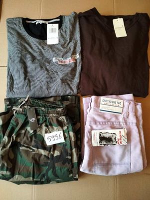 trois paires de shorts de camouflage pour homme et un t-shirt posés sur une boîte en carton