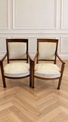 deux chaises en bois posées sur un parquet, près d'un mur blanc