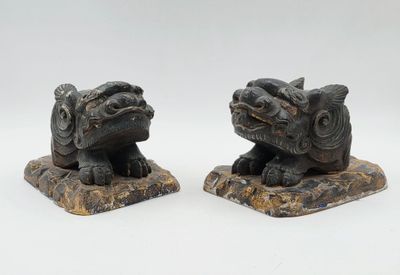 Voici deux statues représentant un chien et un chat assis sur un rocher