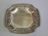 une assiette en argent posée sur une table, sur fond blanc