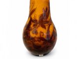 un vase brun orné d'un motif sur une surface blanche