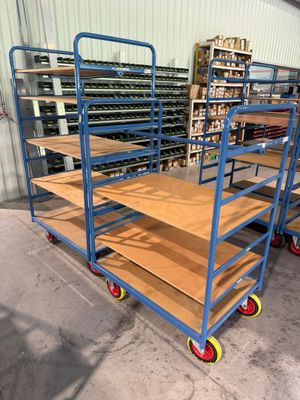 un chariot bleu équipé d'étagères en bois, dans un entrepôt