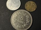 three different coins are shown on a black surface
