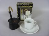 une tasse et une soucoupe blanches posées à côté d'une boîte de café