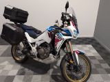 une moto qui est garée dans une pièce dont le sol est en damier