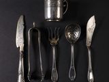 a lot of silver spoons and spoons on a black surface