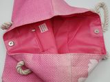 a pink bag with a rope hanging from it ' s side