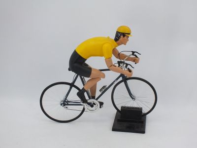 figurine représentant un homme à vélo sur une surface blanche