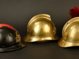 three helmets sitting next to each other on a black surface