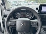 a steering wheel and dashboard of a car in a parking lot