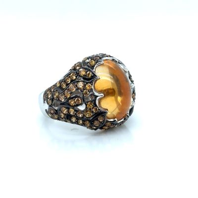 an image of a ring with a yellow stone surrounded by brown diamonds