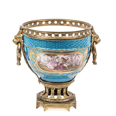un vase bleu et or contenant des fleurs, posé sur un socle