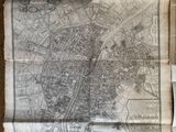 une vieille carte d'une ville, posée sur un morceau de papier, sur une table