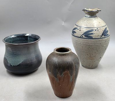 trois vases posés l'un à côté de l'autre sur une table