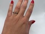 woman ' s hand with red manicured nails and a gold ring