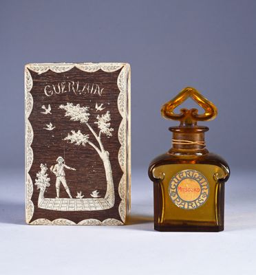 a small bottle of perfume next to a small box