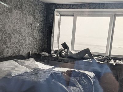 une personne allongée sur un lit dans une chambre dotée d'une fenêtre