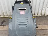an image of a lawn mower sitting on the side of the road