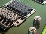 a close up of a green electric guitar with a green string