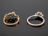 two gold and silver rings with blue stones on a black surface
