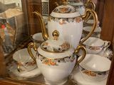 a display case with a tea pot and cups on it
