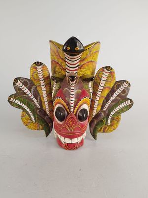 une image représentant un masque coloré orné de plumes sur fond blanc
