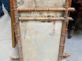 a tall wooden frame with a mirror on top of it