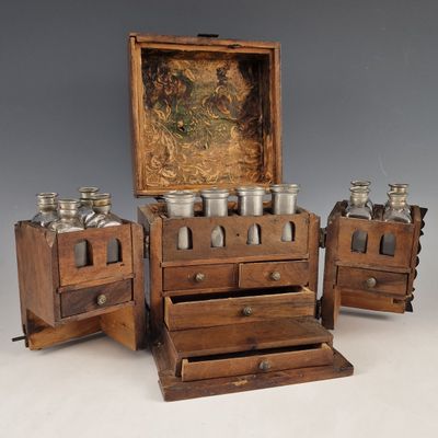 three wooden drawers with jars on them and a painting on the wall