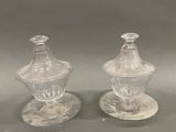 une paire de sucriers et poivriers en verre transparent, posés sur des soucoupes