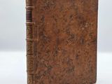 an old book sitting on top of a white surface