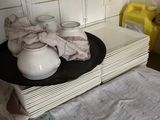 une pile d'assiettes et de tasses posée sur un plan de travail dans une cuisine
